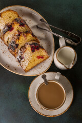 White cup of coffee with fruit tasty cake on a dish