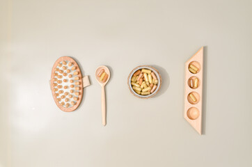 Herb in capsules in wooden bowl on pastel beige background. Beauty products for face and body skin care