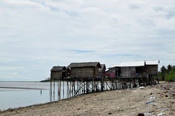 Over water stilt Bajau shanty houses built by indigenous people in the philippines. long shot