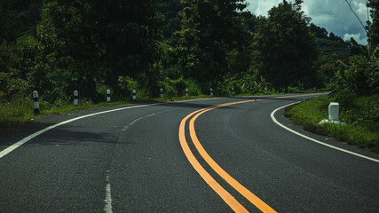 Fototapeta premium Curvy road to the mountain in mountain landscapes after rain in northern Thailand.
