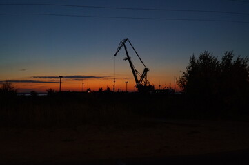 Crane in the port at dusk. Sunset sky.