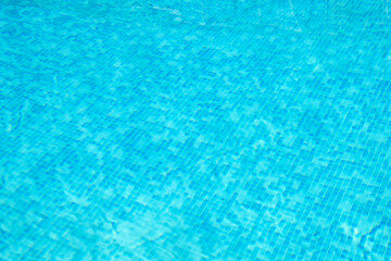 Amazing blue pool water with slight ripples. Top view of a pool with blue tiles texture and slight ripples.
