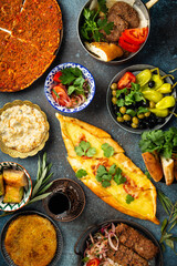 Traditional Turkish food, assorted dishes and mezze appetizers on rustic background from above. Pide, Lahmacun, meat kebab, Turkish meatballs, sweet baklava and Künefe. Middle East cuisine, top view