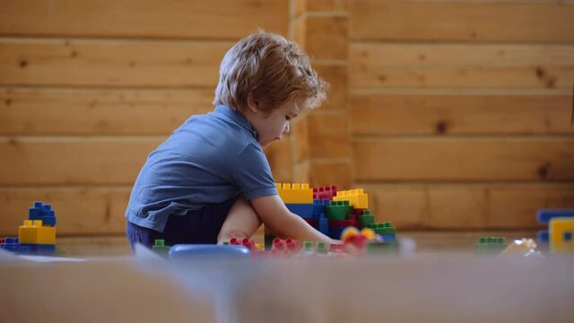 child playing with colorful plastic bricks at home . Toddler having fun and building out of bright constructor bricks. Early learning. Developing toys.