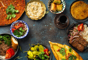 Traditional Turkish food, assorted dishes and mezze appetizers on rustic background from above. Pide, Lahmacun, meat kebab, Turkish meatballs, sweet baklava and Künefe. Middle East cuisine, copy space