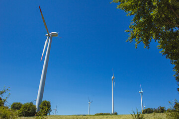 Windmills on a German green field. Wind energy theme. Wind turbines producing electricity