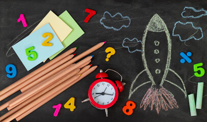Back to school background with rocket and education supplies top view