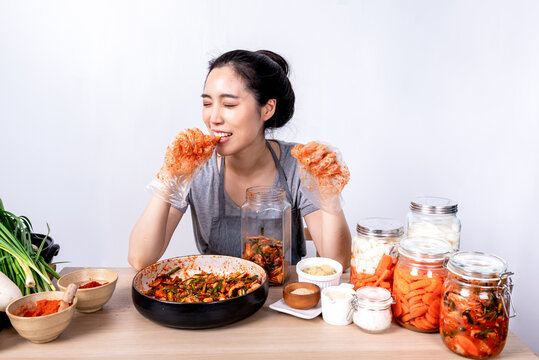 Portrait images of Korean attractive woman is eating Kimchi which she making,  Kimchi which is a fermentation food preservation of Korean people consisting of many fresh vegetables and fruits
