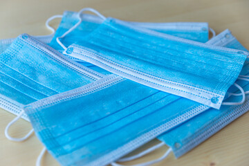 Blue surgical masks on wooden surface
