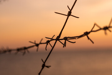 Fototapeta na wymiar barbed wire against sunset