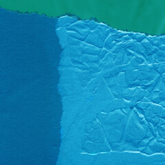 Blue torn paper collage close-up. Texture made from various paper and cardboard parts. Damaged old paper background. Vintage blank wallpaper. Material design backdrop.