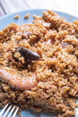 Spanish paella rice with seafood served on a blue plate with prawns close up still