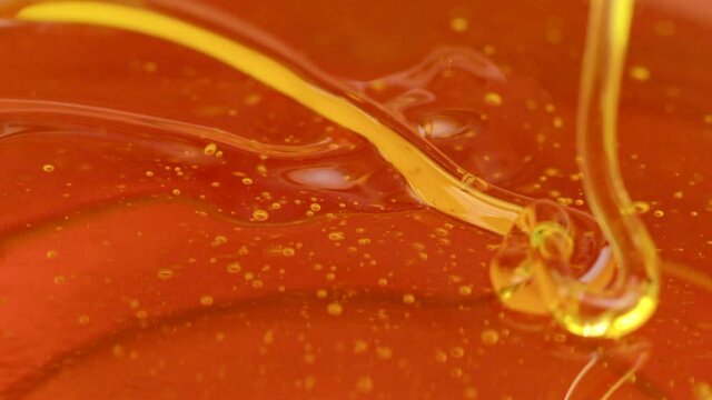 melted pine resin or amber color transparent dense viscous liquid fluid flows in beautiful flow slow motion. Advertising intro for Manufacture of adhesives, sealants, natural wood resin products