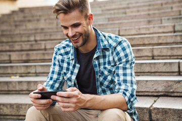 Fototapeta premium Handsome young man using mobile phone