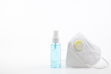 Spray alcohol and medical face mask on white background which they are a respiratory