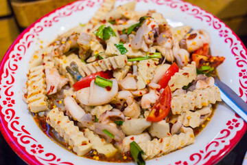 Vietnamese pork sausage, boiled squid and fresh shrimp spicy salad is mixed with sliced tomatoes and herbs.
