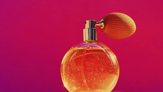 Golden fragrance bottle and shining light flares on pink background, glamorous perfume scent as holiday perfumery product for cosmetic and beauty brand, stock footage