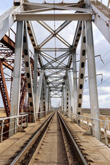 Steel construction of railway bridge with tracks on the river