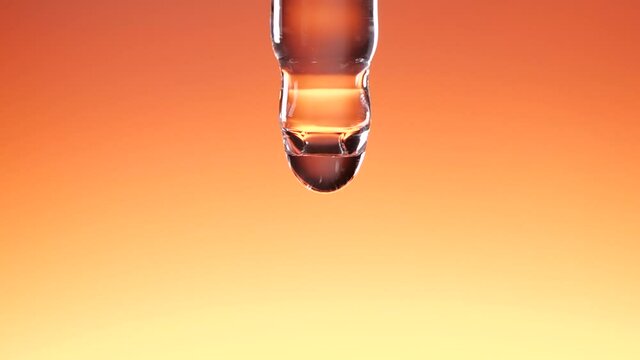 Water dropper in slow motion on orange color background