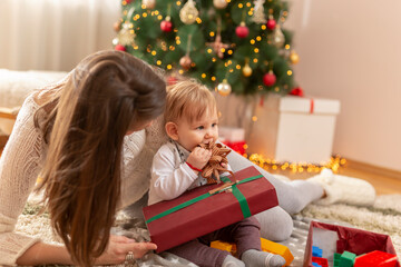 Fototapeta na wymiar Mother and baby boy opening Christmas presents