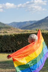 older caucasian woman with lgbt flag