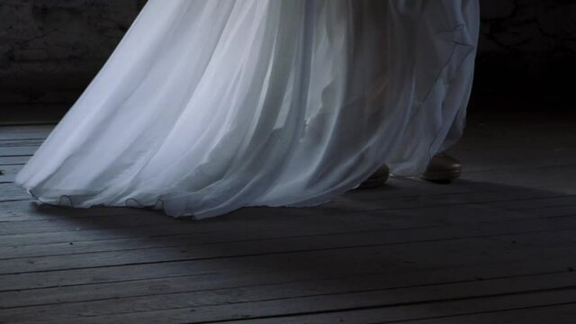 Unrecognizable bride walking in white dress along room