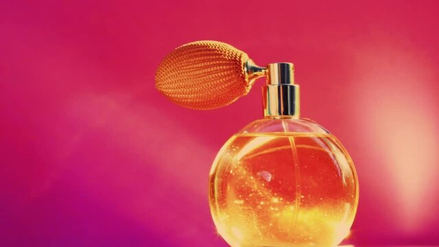 Golden fragrance bottle and shining light flares on pink background, glamorous perfume scent as holiday perfumery product for cosmetic and beauty brand, stock footage