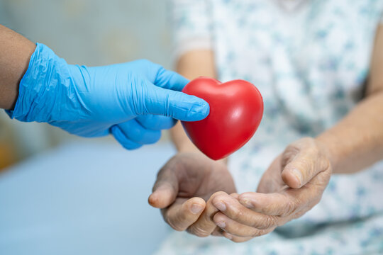 Doctor give red heart to Asian senior or elderly old lady woman patient, healthy strong medical concept - Powered by Adobe
