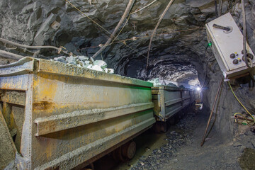 Wagons minecarts with gol ore in underground mine tunnel © Mishainik