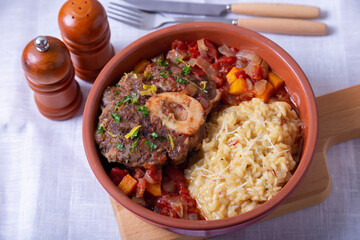 Ossobuco. Veal (beef) shanks with saffron risotto in milanese, gremolata and sauce. Traditional Italian dish. Close-up.