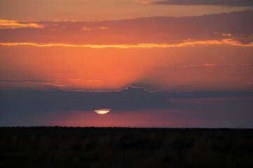 Dramatic sunset sky with dark clouds and red sun