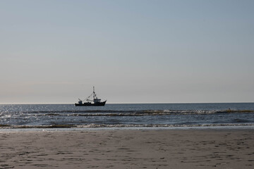 a small fishing boat off the coast, at sunset