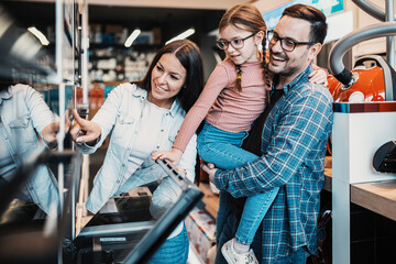 Happy family buying oven in store.