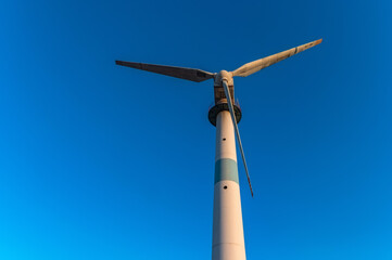Close up of old abandoned wind turbine and the blue sky