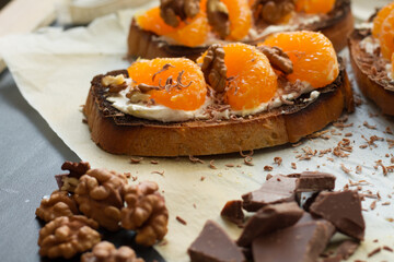 Delicious toast with sweet tangerine on black wood background