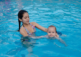 Fototapeta na wymiar Bebe en la piscina con la madre. 