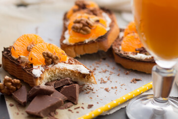 Delicious toast with sweet tangerine on black wood background
