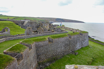 Walled area and full of grass with the sea next to it