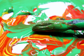 close-up colorful paint splashes with brush background