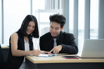 Asian business woman point at laptop screen  work together with boss manager