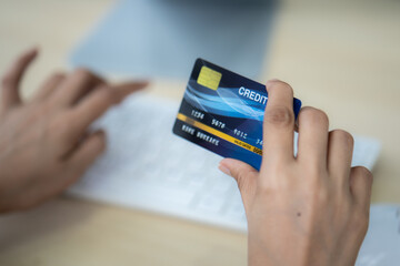 Business woman hand hold credit card to shopping internet online with laptop computer