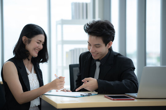 Asian business woman point at laptop screen work together with boss manager