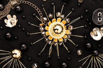 Close up golden embroidery of flowers and black beads on fabric