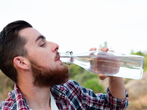 young caucasian man in work clothes having breakfast in the field - Powered by Adobe