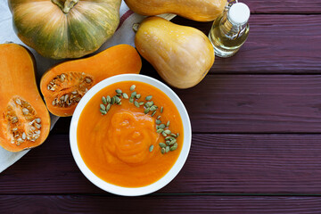 Top view of pureed pumpkin soup in a white bowl on dark table