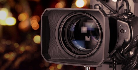 Fototapeta na wymiar Professional video camera on dark bokeh background