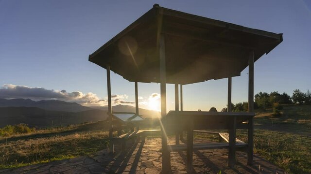 timelapse kiosko con monta&ntilde;as y nubes de fondo