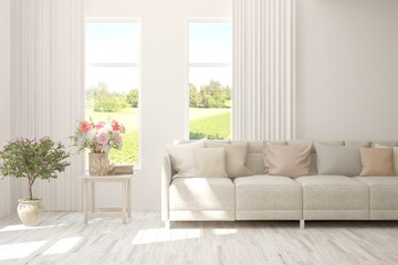 White living room with sofa and summer landscape in window. Scandinavian interior design. 3D illustration