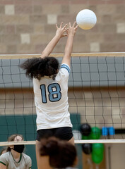Young girls making plays in a competitive volleyball game