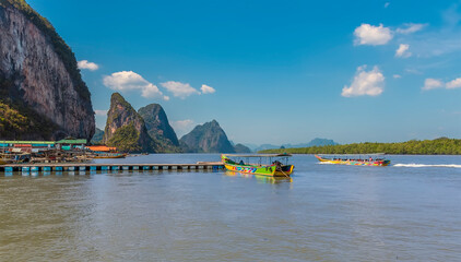 Traditional longtailed speed boats prepare to leave the settlement built on stilts of Ko Panyi in Phang Nga Bay, Thailand